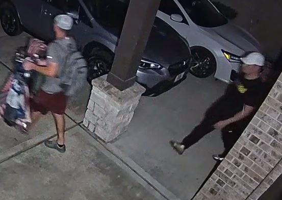 Camera footage photo of two male suspects leaving a residence. 
